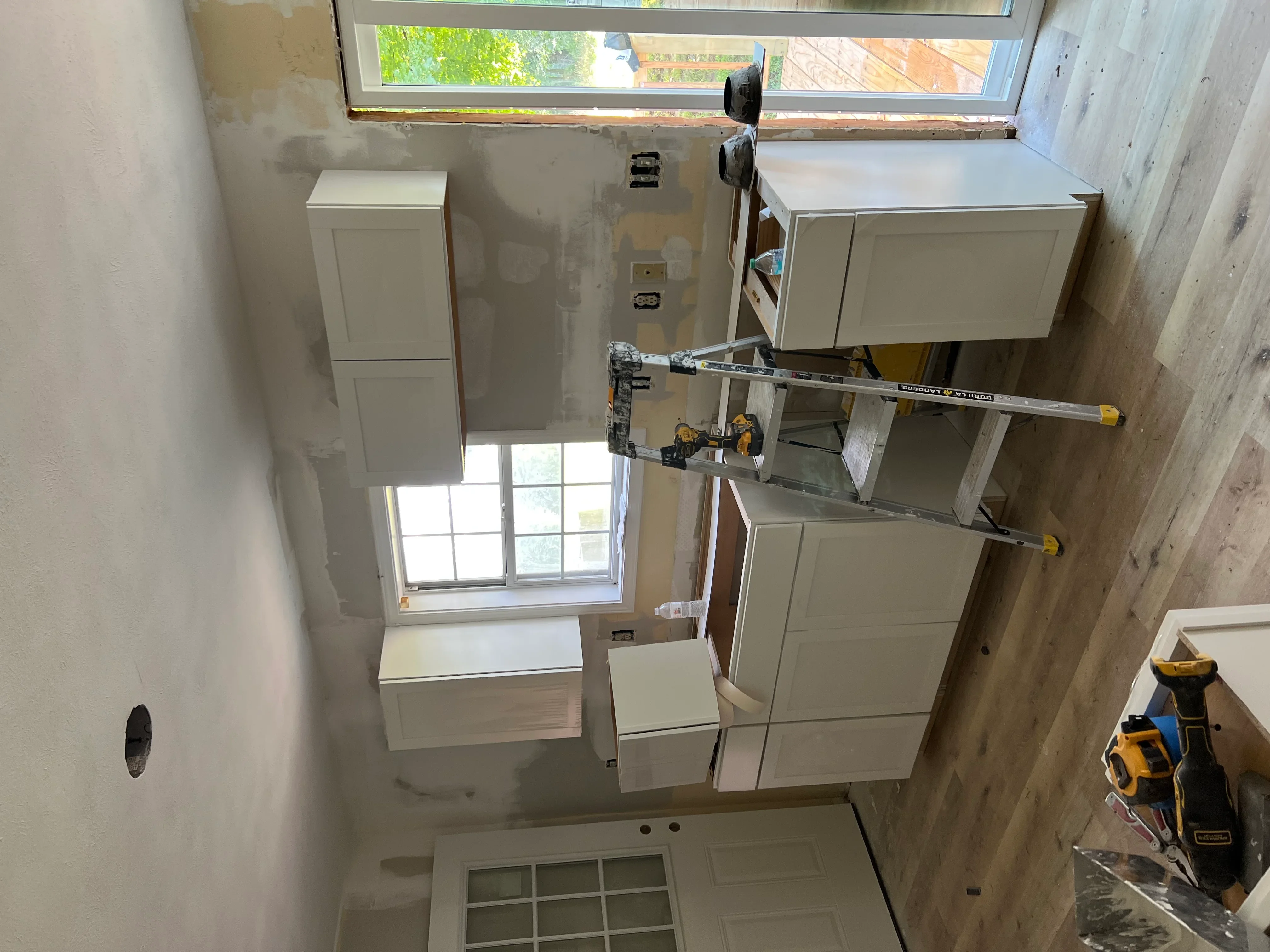 White bathroom cabinets and vanities installed with electrical rough-in and drywall finishing