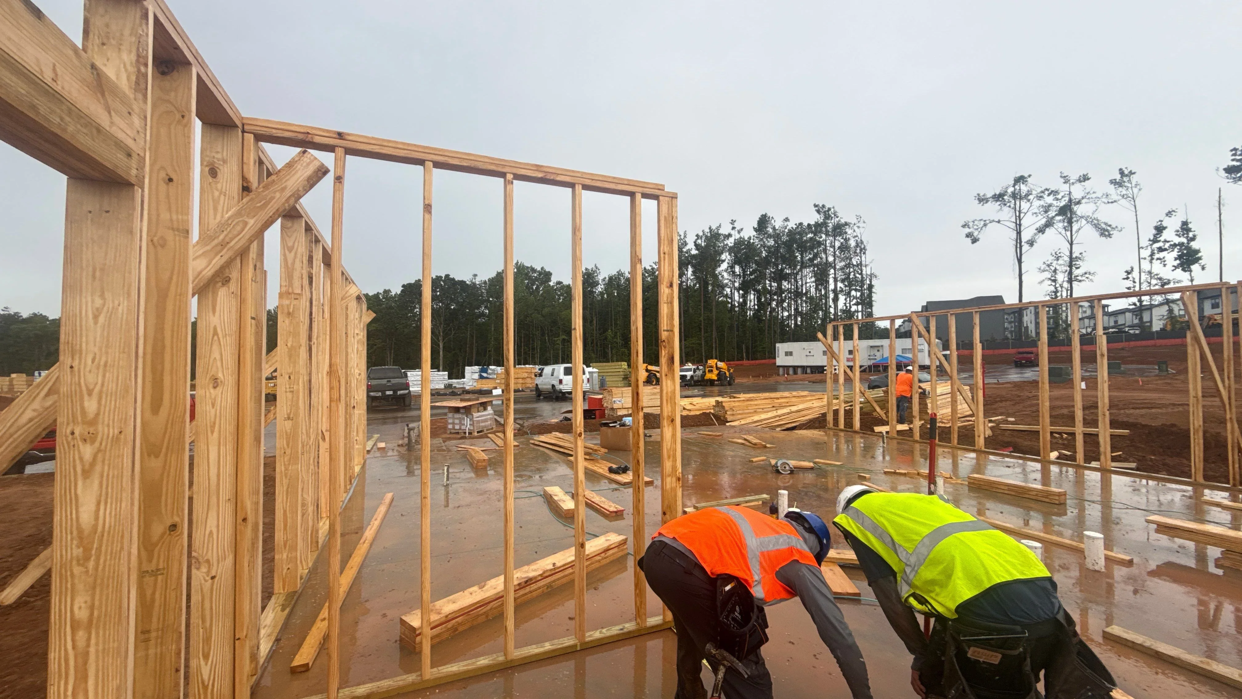 Wood framing structures with vertical studs and beams on concrete foundation at commercial construction site