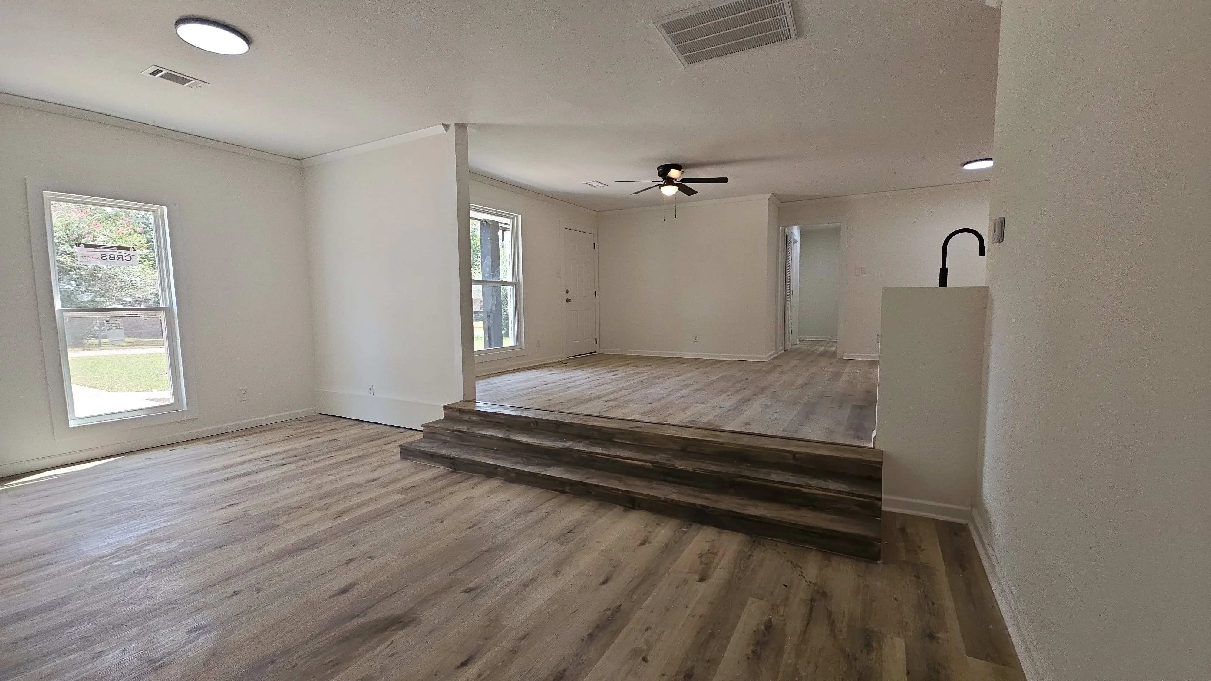 Open concept interior with vinyl plank flooring, white drywall, built-in wet bar, and recessed lighting